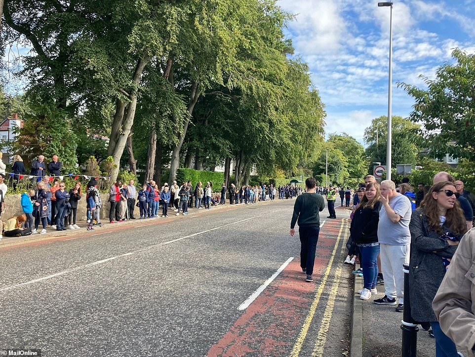 Well-wishers line the road in preparation for the arrival of the cortege in Cults, a suburb on the western edge of Aberdeen